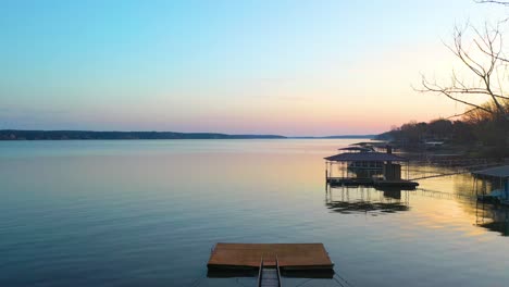 drone rising over wooden boat dock with bridge on vacation destination in grand lake o' the cherokees in oklahoma