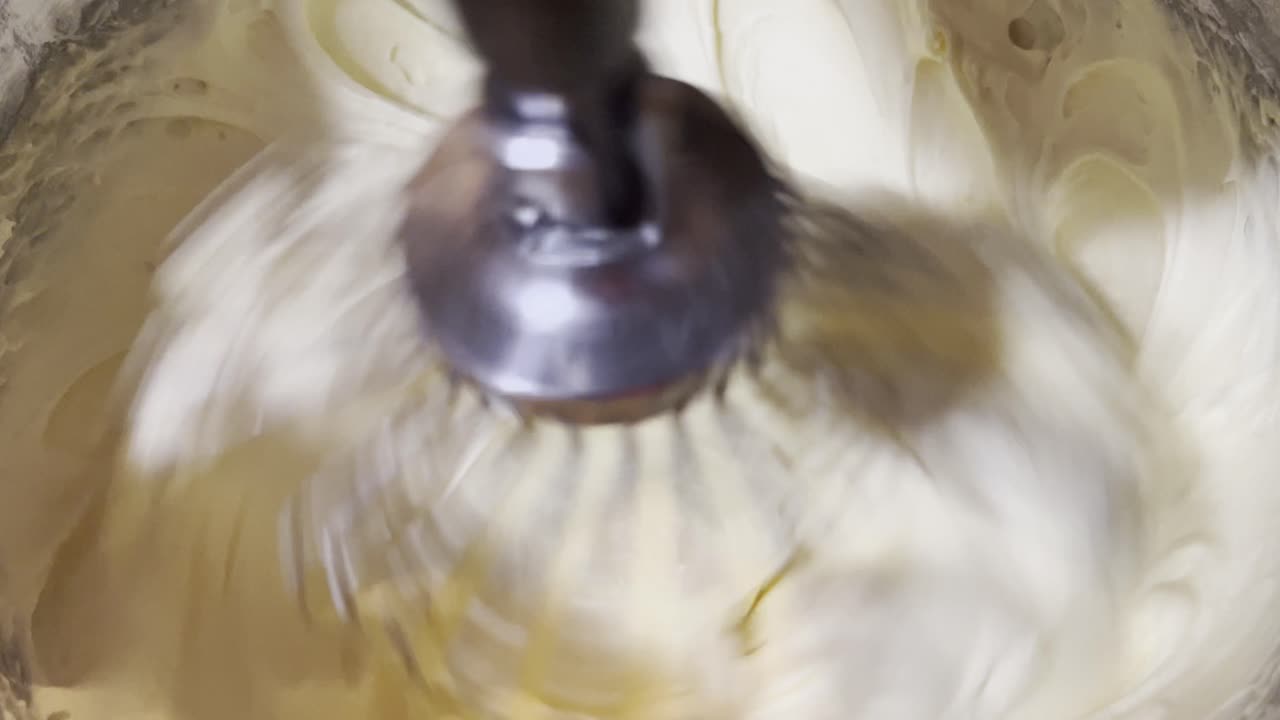 Smooth cookie batter being whisked in a standing mixer, close up