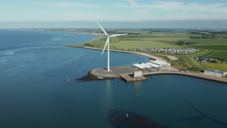 wind turbine generating clean energy with sea farm and seafood restaurant in kamperland, zeeland, netherlands
