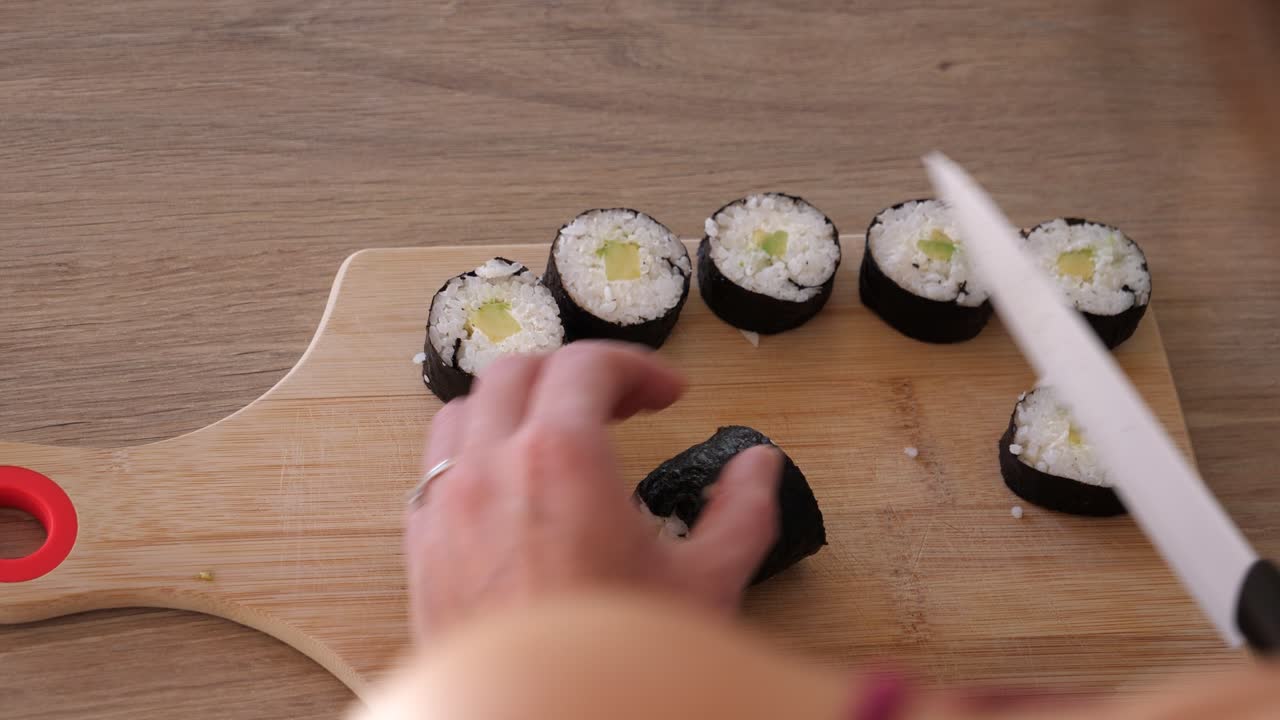 Täydellisen sushirullan leikkaaminen terävällä veitsellä