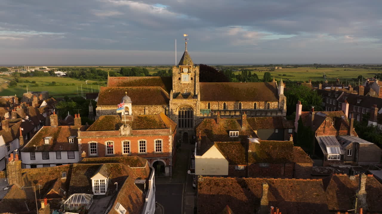Exterior View Of Saint Mary Church With Birds Flying Over The Town At Dusk In England, UK. - aerial pullback shot