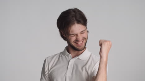 caucasian happy man in front of camera on gray background.