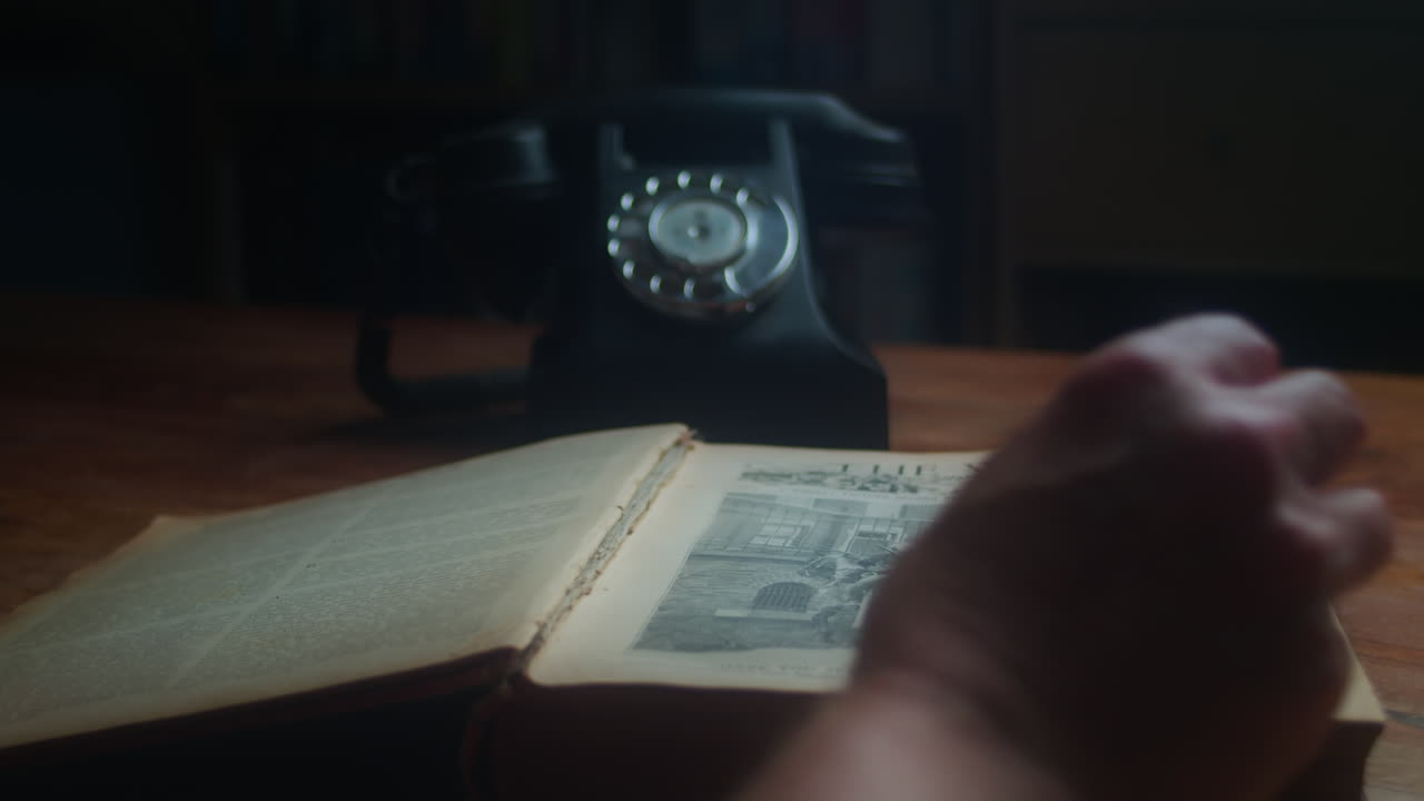 Man Take His Glasses Before Reading An Old Book Then Answer Call Through Telephone In His Office Desk. - close up