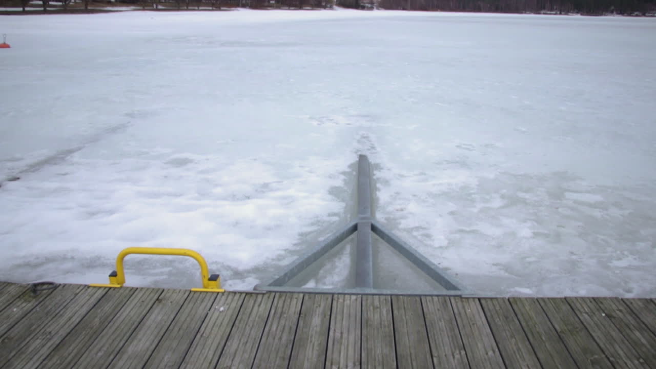 Tilt up from wooden boardwalk leading to pristine snow cover lake and woodland horizon Katinkulta Vuokatti Finland
