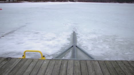 incline hacia arriba desde el paseo marítimo de madera que conduce a la cubierta de nieve prístina lago y horizonte boscoso katinkulta vuokatti finlandia