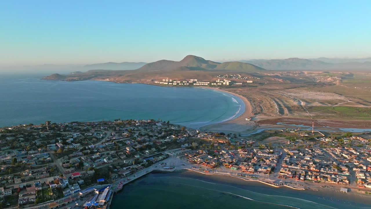 dolly en vista aérea de la península de tongoy con playa socos y las áridas montañas del norte de chile en el horizonte