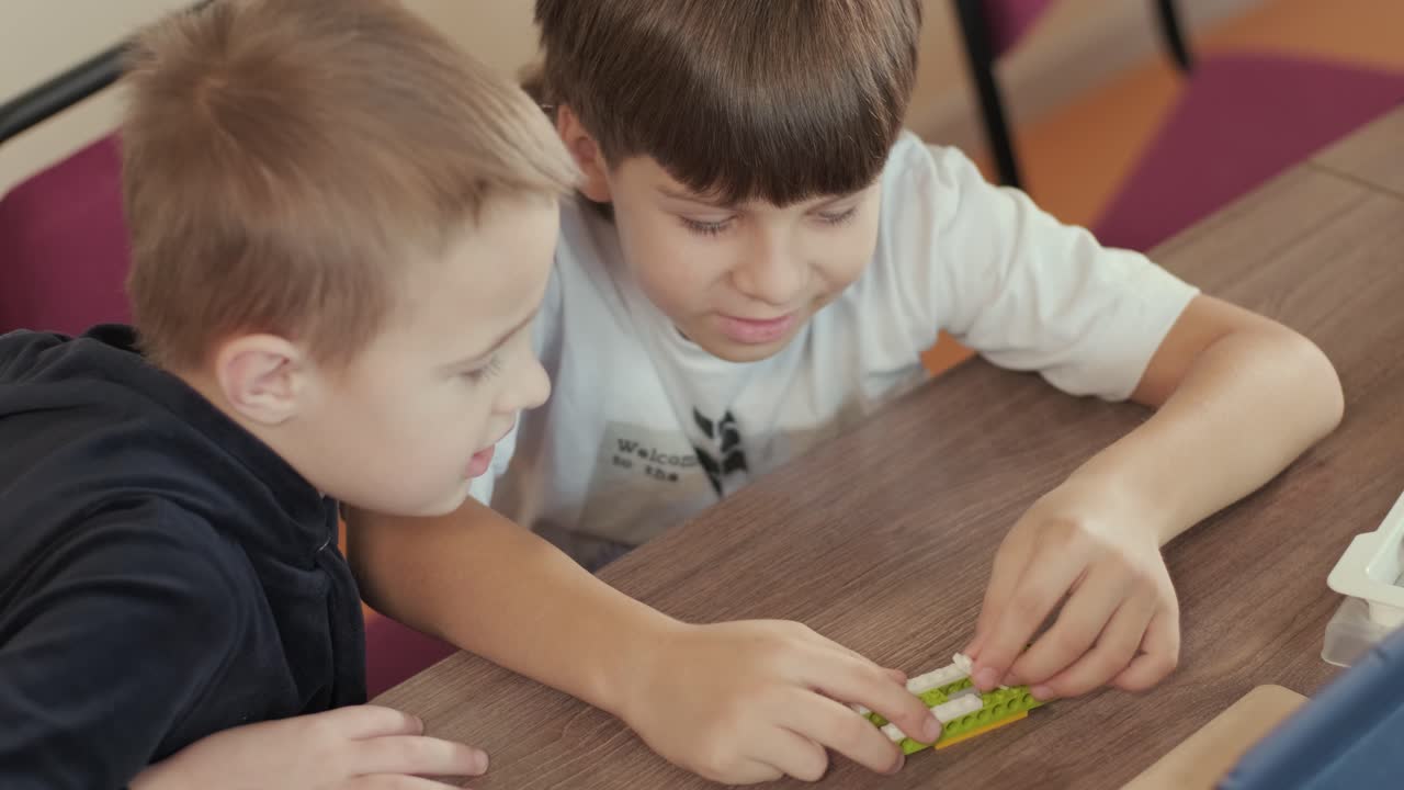 los niños participan en actividades de aprendizaje básico, montando kits de robótica con enfoque y trabajo en equipo en un entorno de aula