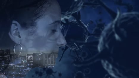 animation of a mixed race woman profile over covid-19 cells with a cityscape