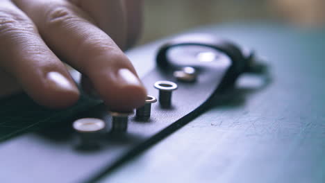 Professional-worker-checks-silver-eyelets-positions-closeup