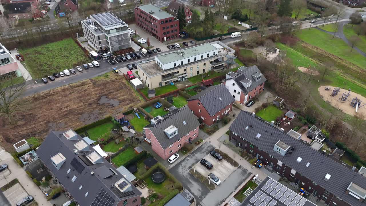 Aerial flyover german neighborhood with residential apartments and office buildings. Solar panels on rooftop of modern buildings. Top down shot.