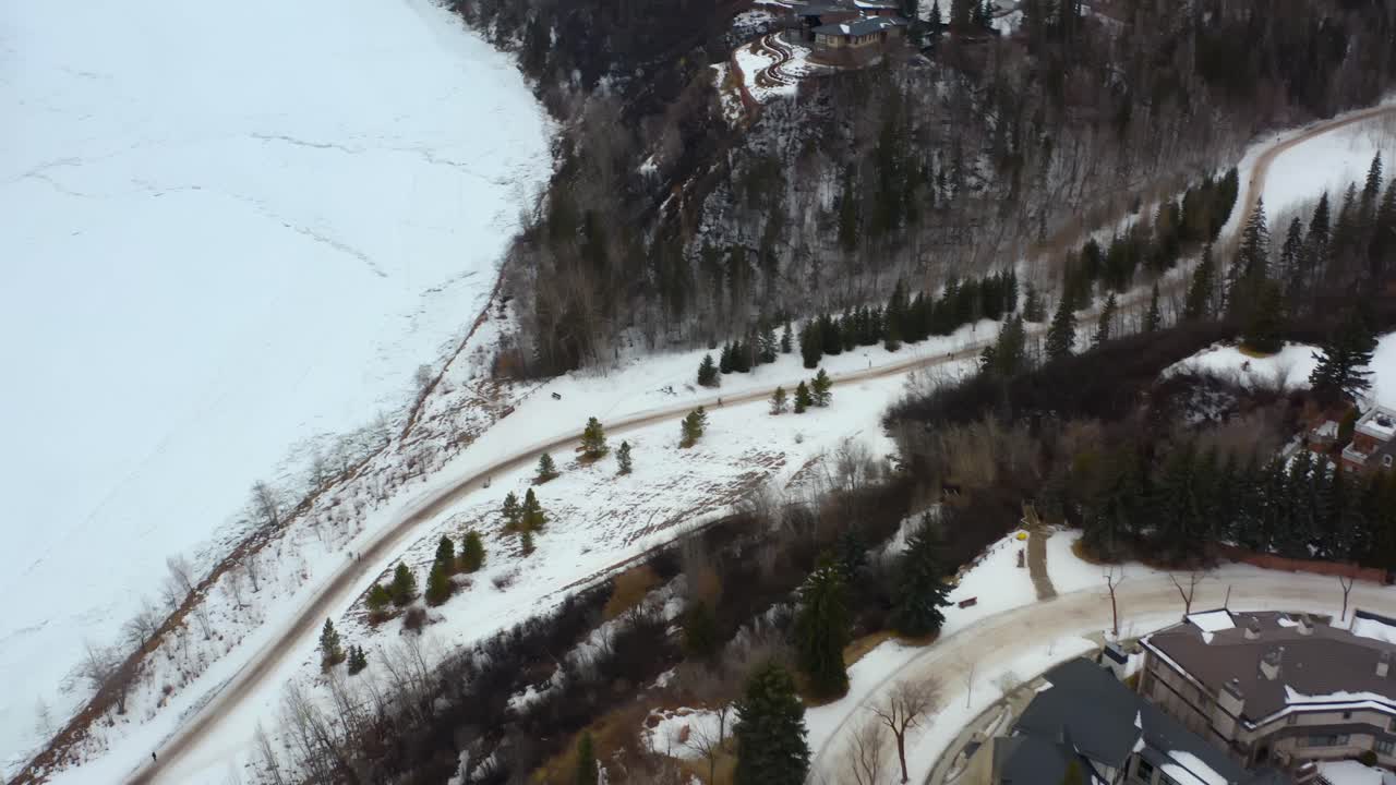 dron aéreo vuela sobre twist en alberta edmonton valley ridge casas masivas de glenora vista de pájaro de invierno por el río saskatchewan del norte por un parque cubierto de nieve que separa las casas en la ladera 4-4