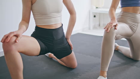 mujeres atletas estirando las piernas sala de yoga primer plano. pareja de deporte disfrutando de fitness