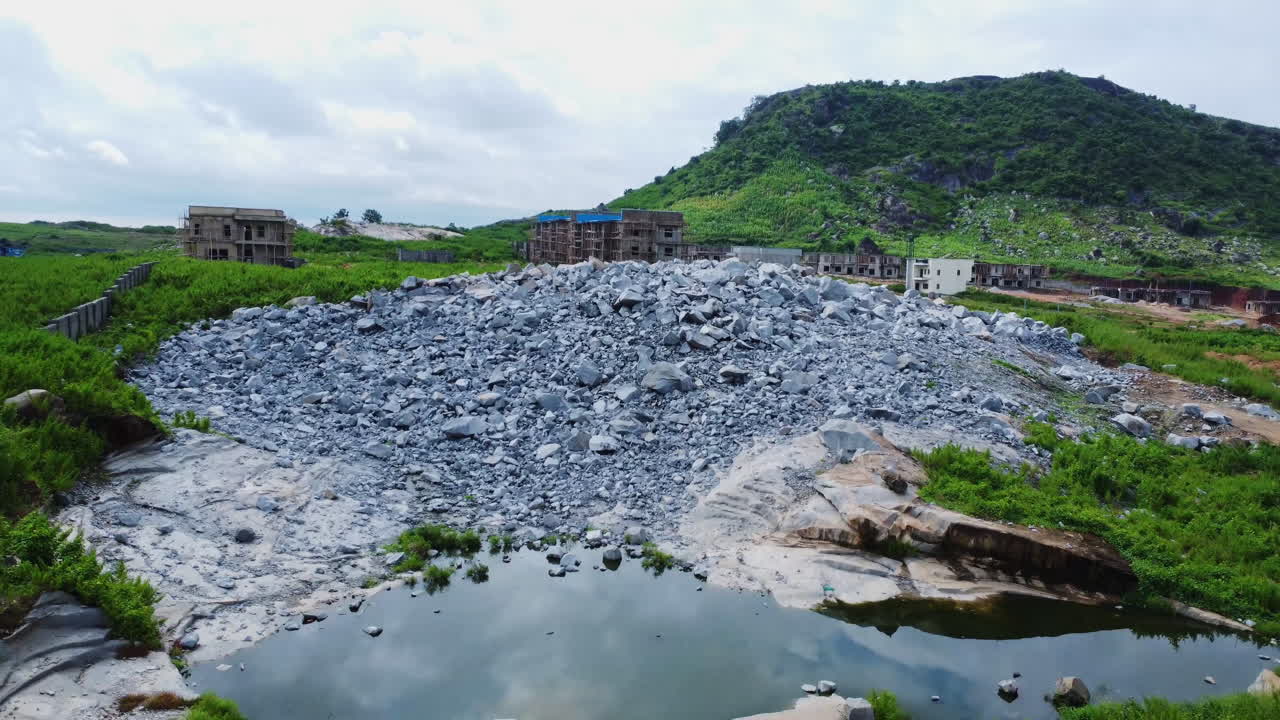 Low aerial of rubble and crushed rocks at the edge of a construction site in the countryside of Nigeria, Africa