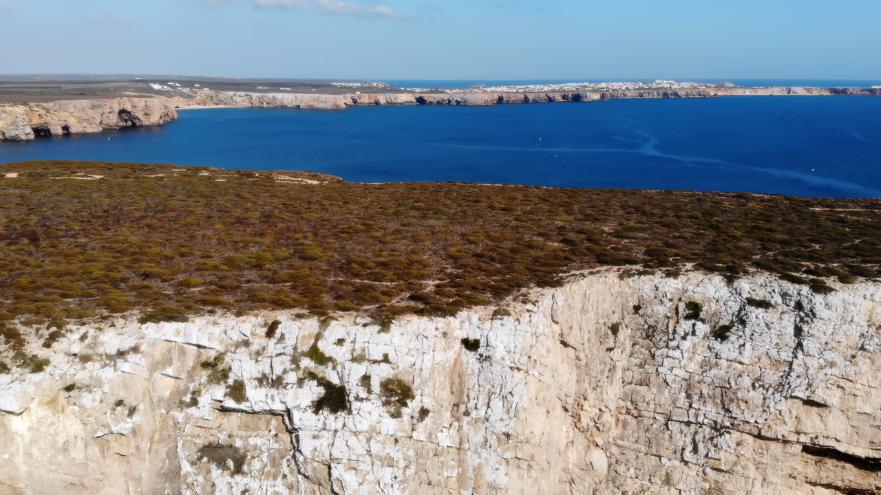 Aerial Cliff Edge Above Blue Ocean, Stark White Rock Face And Dense Coastal Heath On Windswept Escarpment. Media