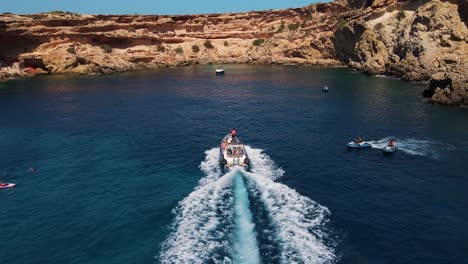 party goers on boat find secluded beach in ibiza, spain to moore their boat