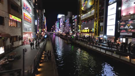 evening view of a vibrant city canal with neon signs