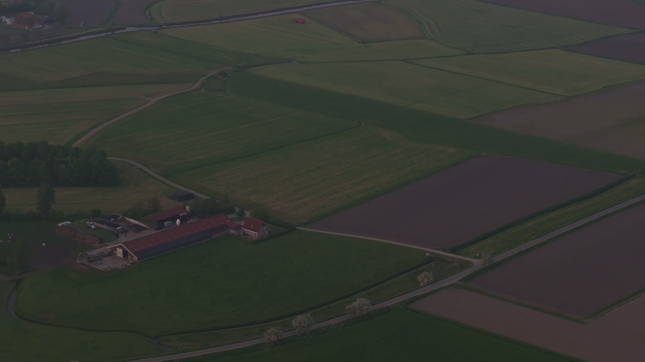 Aerial view of Piaam with tractor, meadow, mowing, showing vibrant rural scenery in Netherlands