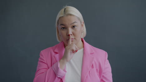 woman in pink blazer with questioning expression