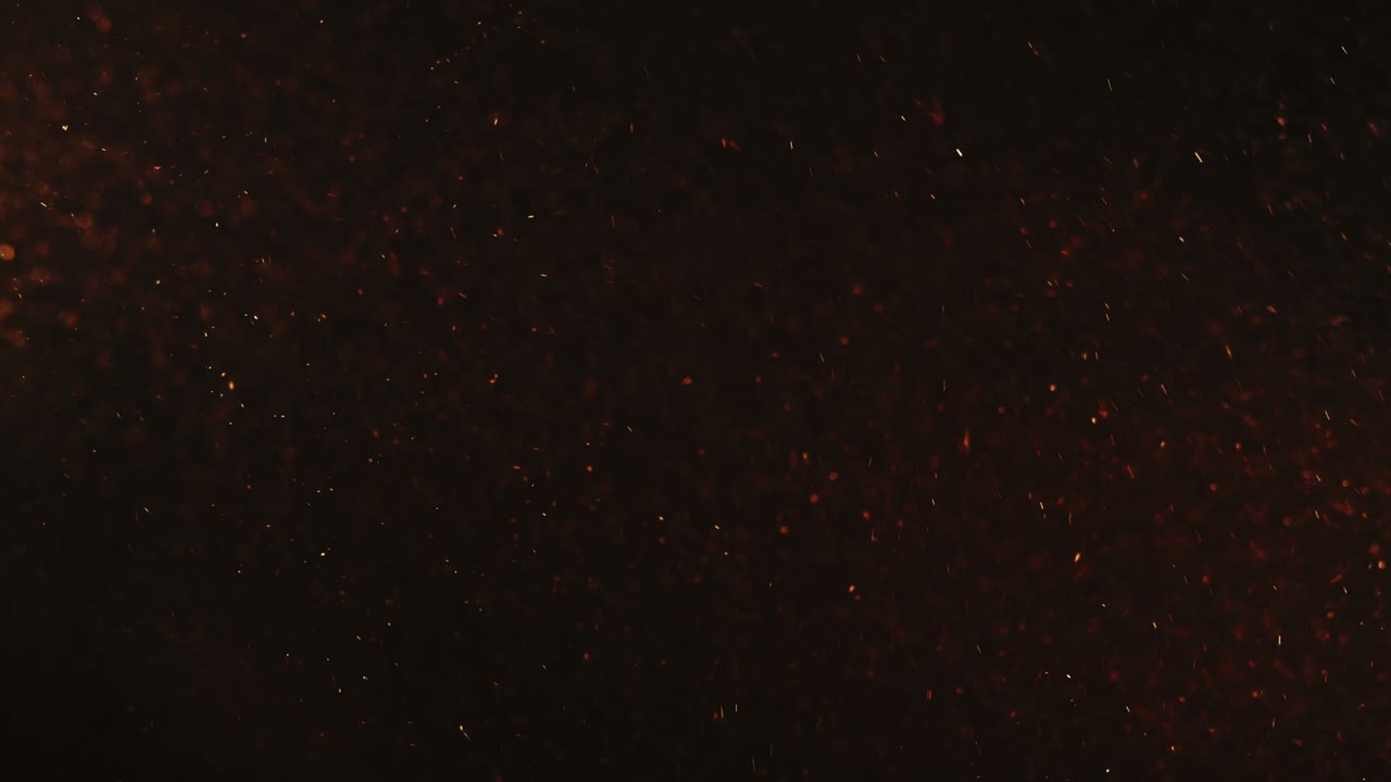 las chispas el fondo abstracto las partículas naranjas borrosas