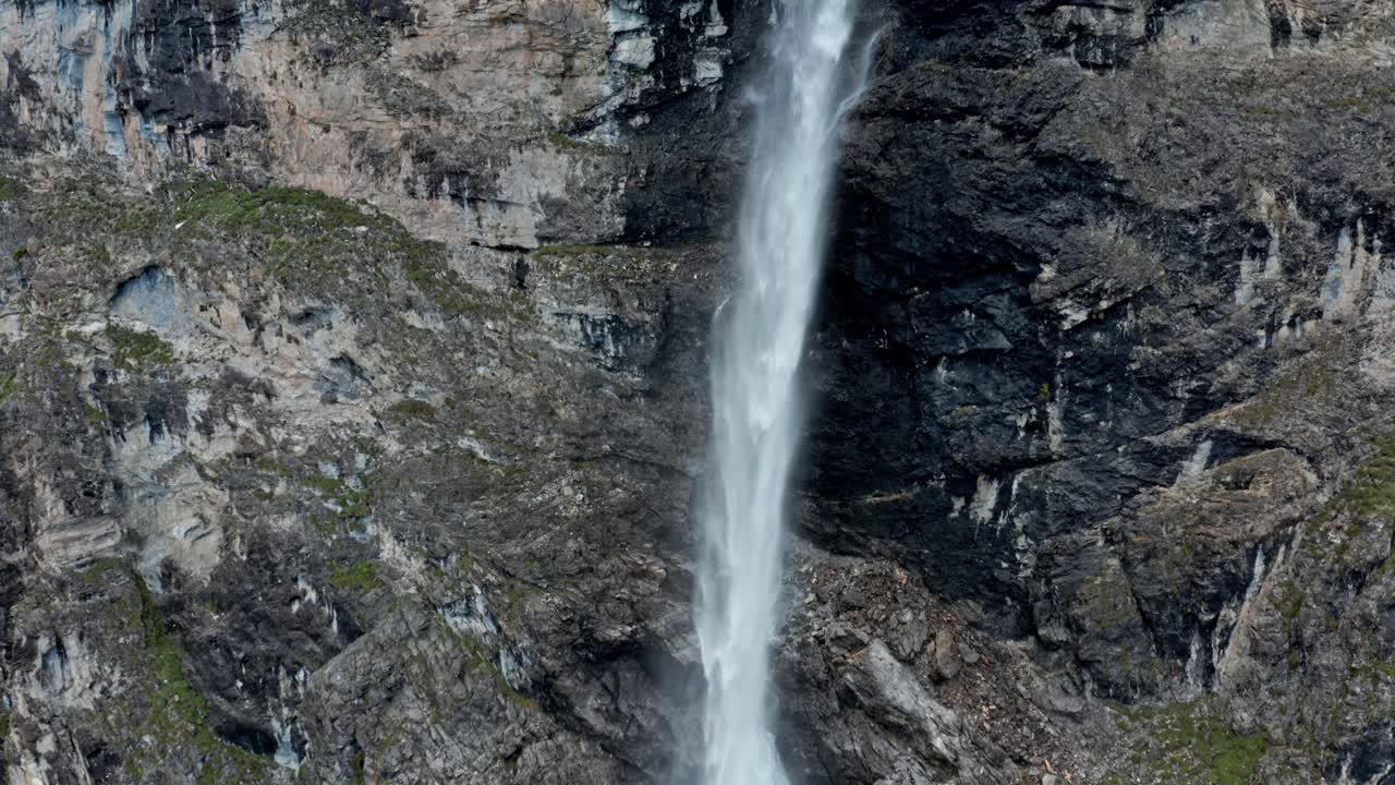 cascada de montaña que desemboca en un lago alpino, rodeado de exuberante vegetación, luz del día, paisaje natural tranquilo