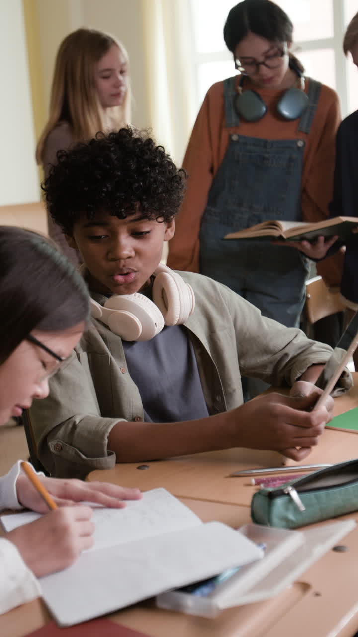 Diverse group of students in a classroom studying and using a tablet