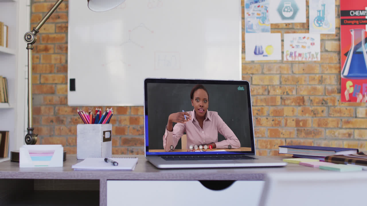 Mixed race female teacher displayed on laptop screen during video call