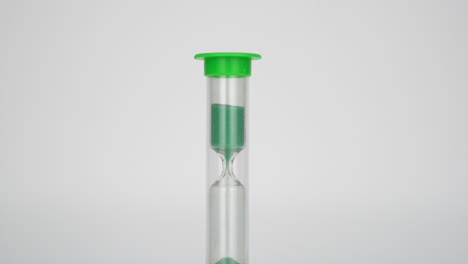 reloj de arena médico. la arena mide el tiempo. la arena verde desemboca