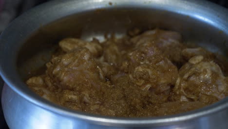 trozos de pollo marinado cocinados en una olla de acero