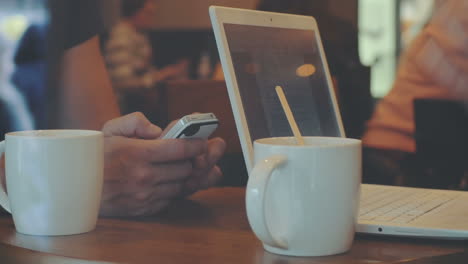 Hombre-Y-Mujer-Trabajan-En-Una-Cafetería-Usando-Gadgets