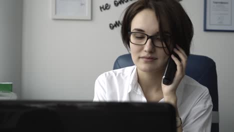 Mujer hablando por teléfono en la oficina