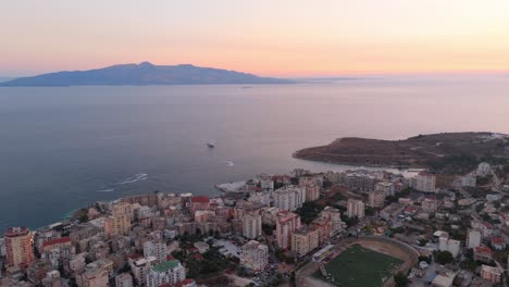 saranda, albania coastline at sunset with distant mountains and a calm sea , aerial view