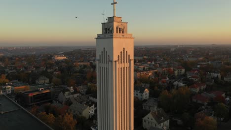 Drone-aerial-view-of-flying-birds-near-church-in-Kaunas,-Lithuania