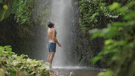 Attraktiver-Mann,-Der-Vor-Wasserfall-Im-Regenwald-Steht