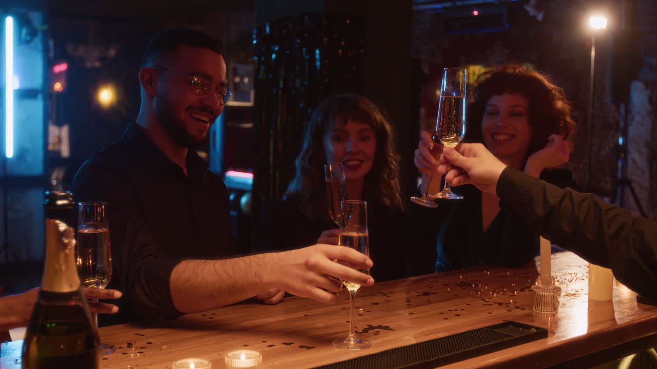 Group of friends celebrating at a bar with champagne