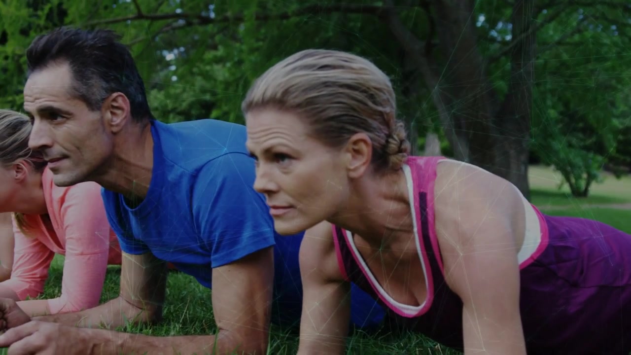 Le leader se mettant en planche sur les avant-bras, les partenaires le rejoignant, un minuteur animé guidant un cours de fitness en groupe sur l'herbe d'un parc.