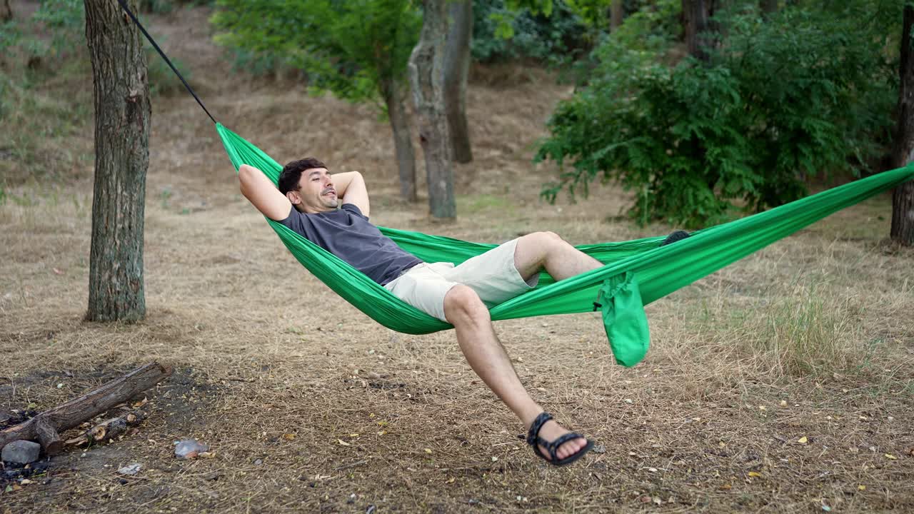 hombre relajándose en una hamaca en un bosque