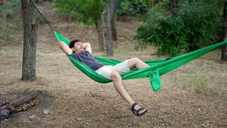 hombre relajándose en una hamaca en un bosque