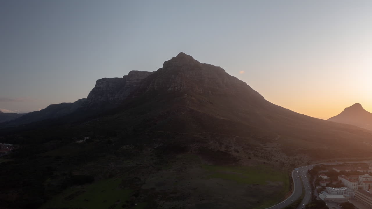 Hyperlapse con drone al tramonto di montagne accanto alla città.