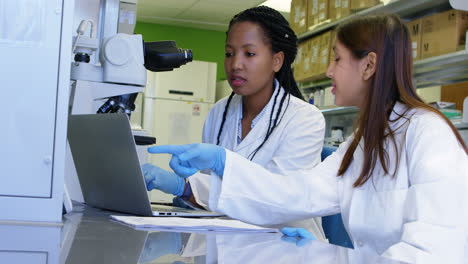 Team-of-scientists-discussing-over-a-laptop-4k