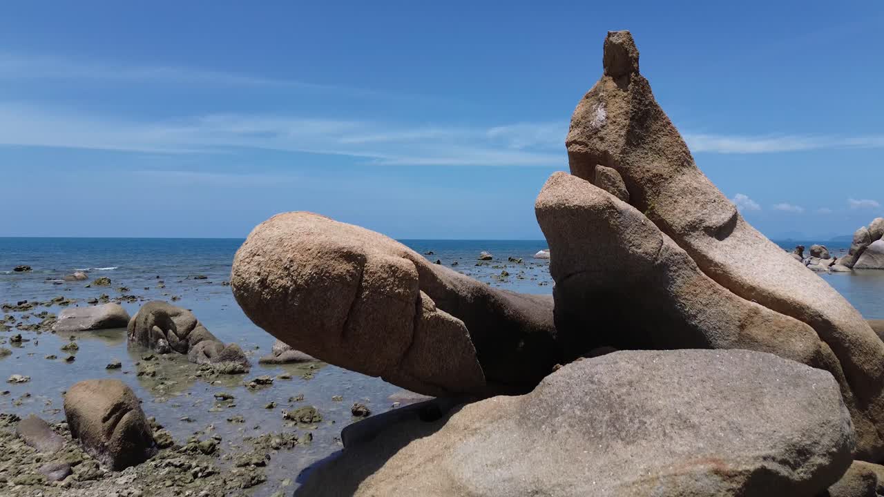 Aerial drone footage of Lamai Beach in Koh Samui, Thailand, featuring turquoise ocean, rocky shoreline, tropical island horizon, and scenic coastal landscape under clear tropical skies