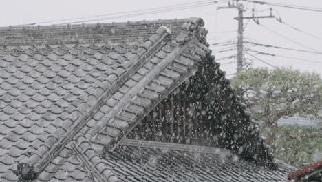 kawara - traditional japanese roof tiles during heavy snowfall at wintertime in tokyo, japan