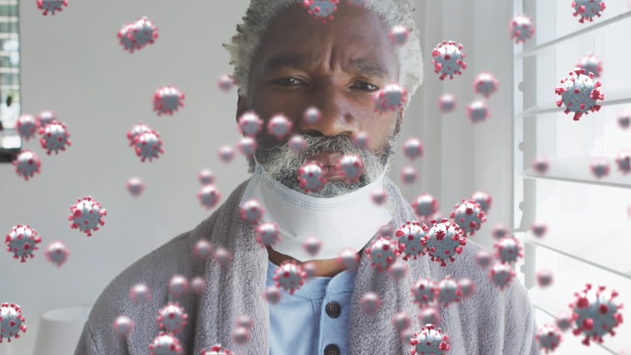 Animation de cellules virales au-dessus d'un homme afro-américain âgé portant un masque facial.