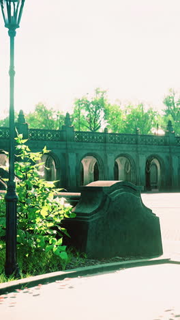 a park with a stone bench and a lamp post