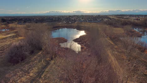 this short left pan shows one of the many parks in greeley colorado along with the urban cityscape and the rocky mountains in the distance