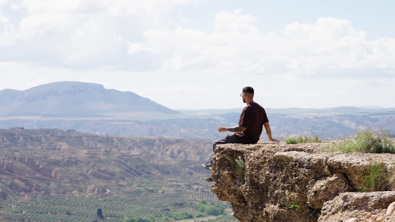 Tourist contemplating gorafe desert landscape from cliff
