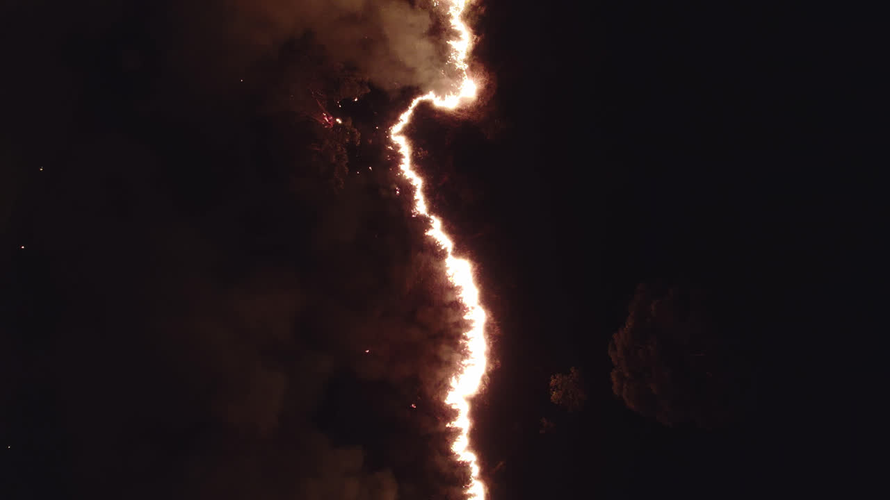Climate change- Aerial view of Wild fire at night showing fire spreading through line