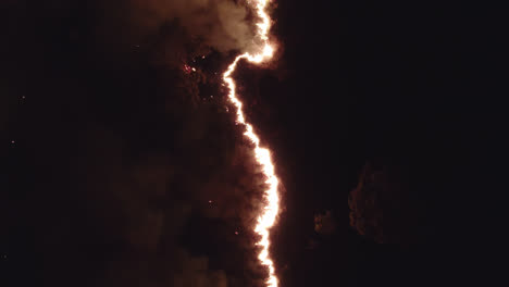 climate change- aerial view of wild fire at night showing fire spreading through line