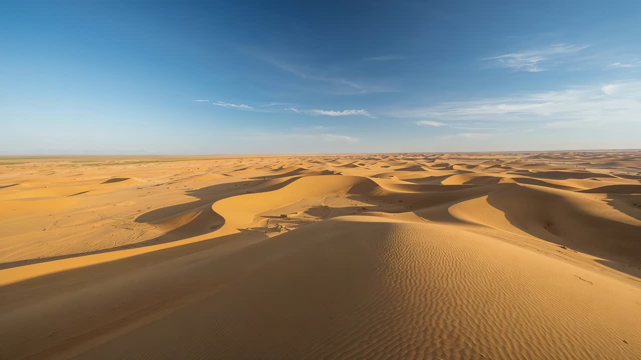 Riprese aeree mozzafiato con drone che rivelano vaste dune di sabbia sotto il sole basso, mostrando increspature, ombre, tracce