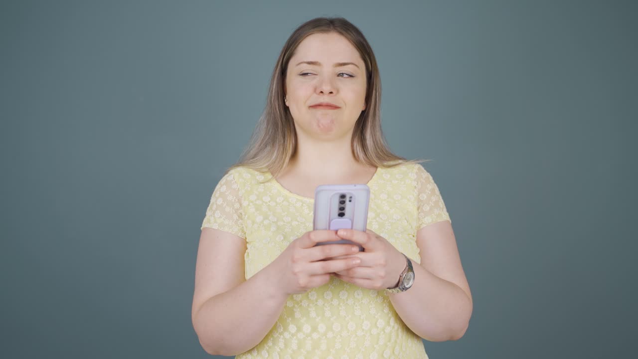 행복한 젊은 여성이 전화로 문자 메시지를 보내고 웃고 있습니다.