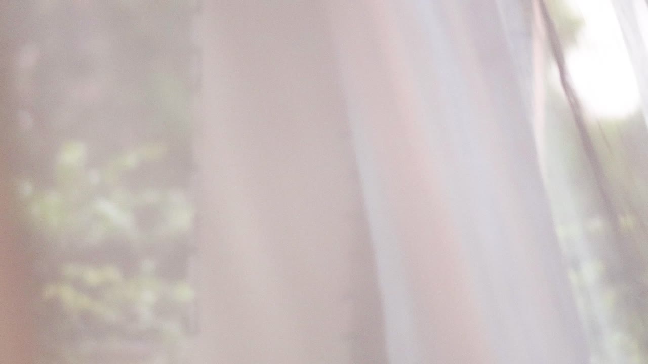 야외의 초록색이 눈에 띄는 가운데 천천히 움직이는 커튼